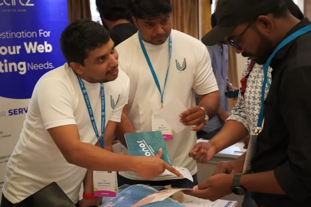 Ucartz team members with a visitor at WordCamp Kerala in Kochi