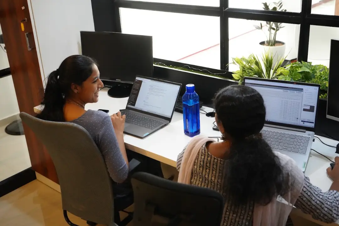 Two Ucartz team members working at their laptops in our office in Kerala, India