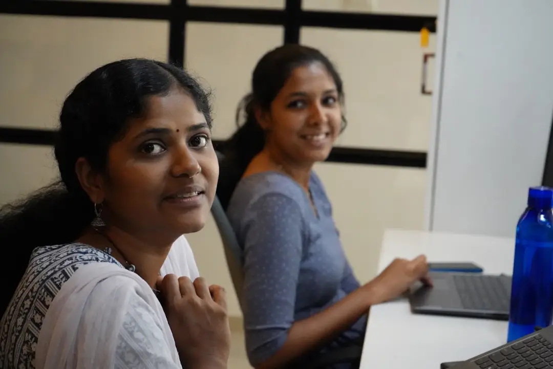 Two Ucartz team members at work on their laptops in our office in Kerala, India