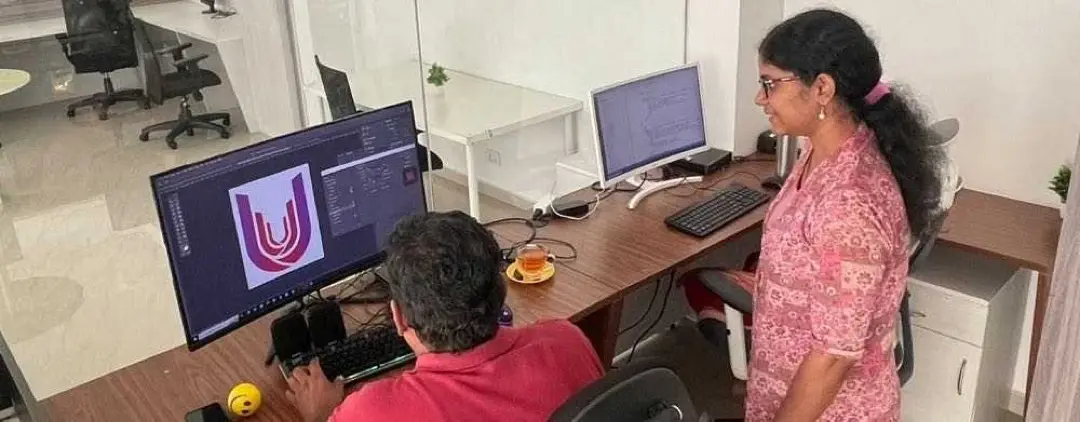 Two Ucartz team members working on a design at a desk in our office in Kerala, India